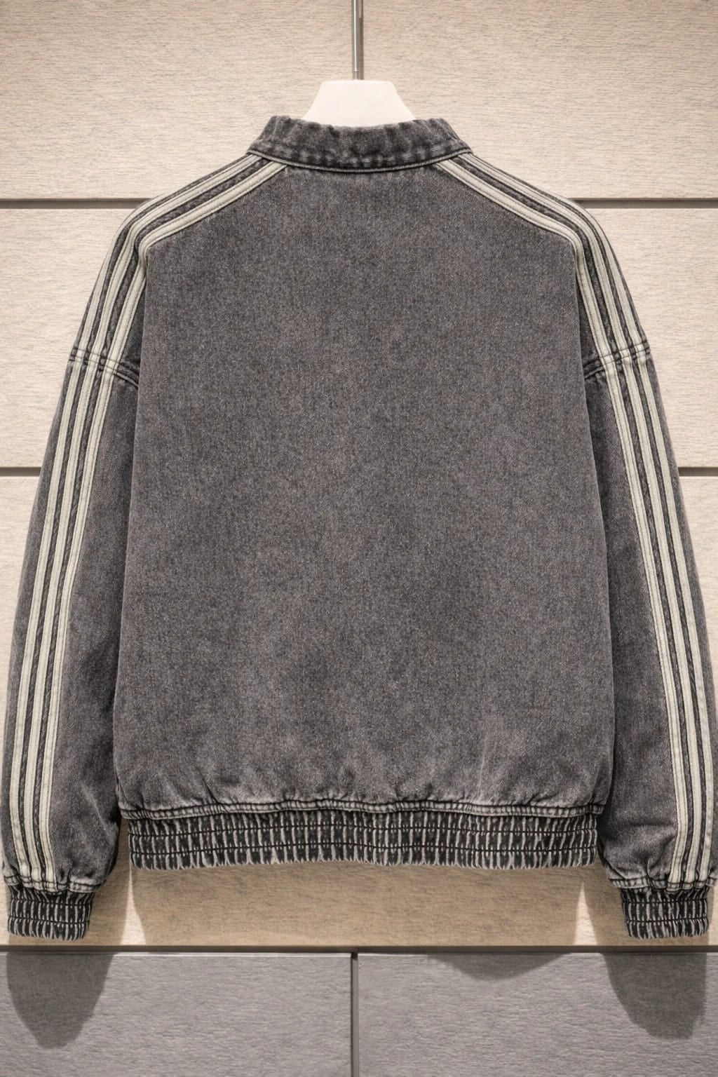 Gray jacket with striped sleeves on a wooden surface