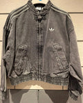 Gray denim jacket with Adidas logo on a wooden surface